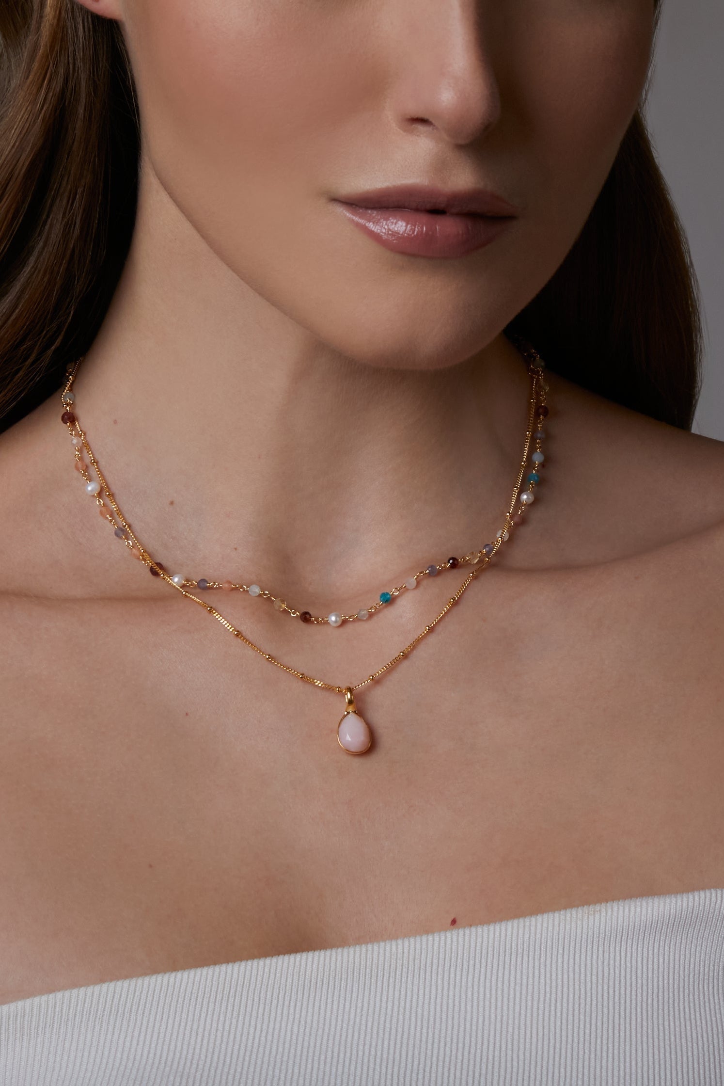faceted pink opal charm on a gold satellite chain 