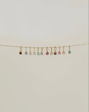 Necklace with small colorful charms on a light beige background
