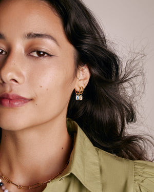 a woman wearing several hoop earrings