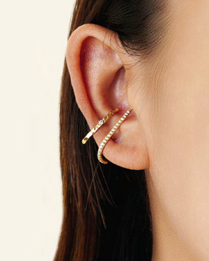 a woman wearing two  ear suspenders with a cubic zirconia