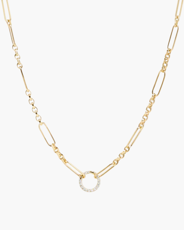 Gold necklace with a small circular pendant on a light gray background