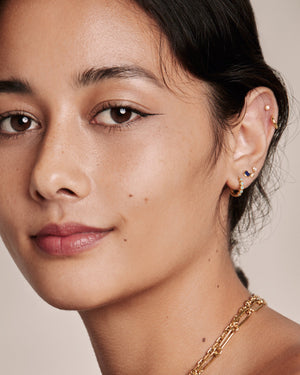 woman wearing a mix of earrings including Mini lapis lazuli stud earrings