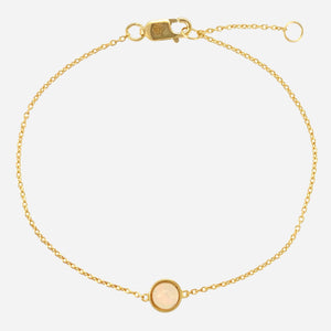 Gold bracelet with a round Opal charm on a white background