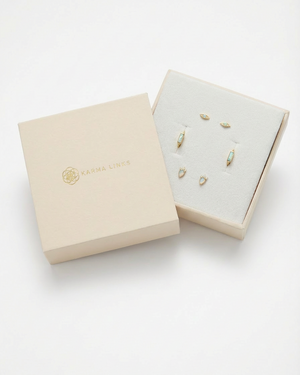 Open beige jewelry box with gold earrings on a white background