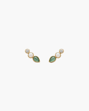 A pair of small gold-toned stud earrings on a textured off-white background. Each earring features a round clear stone, a small oval pale pink stone, and a teardrop-shaped green stone.