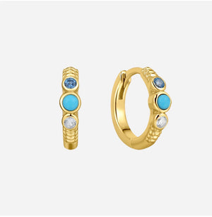 Gold hoop earrings with blue gemstones on a white background