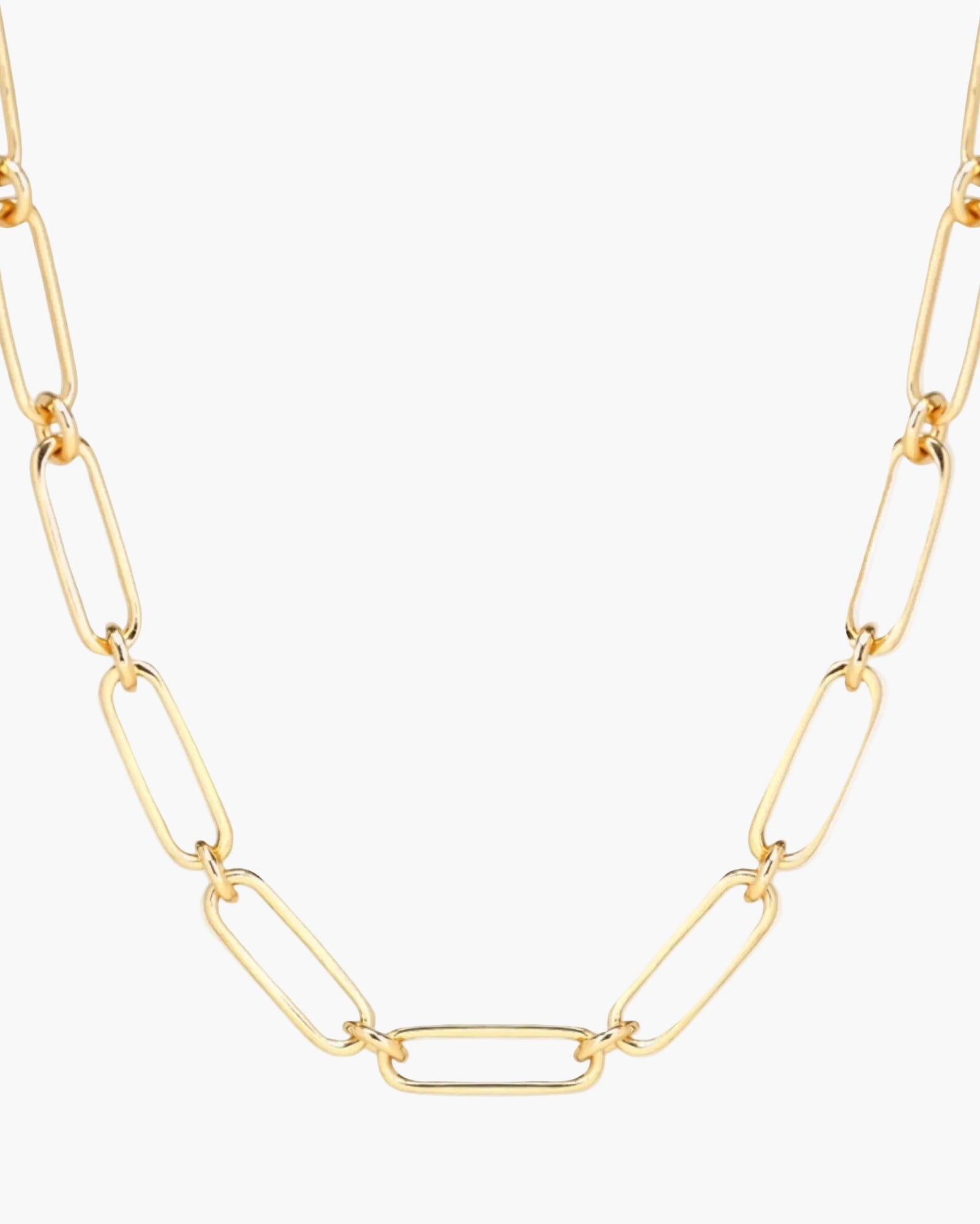 Gold chain necklace on a light beige background