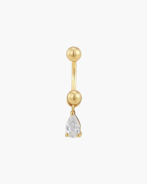 Gold belly button ring with a teardrop-shaped gemstone on a light beige background