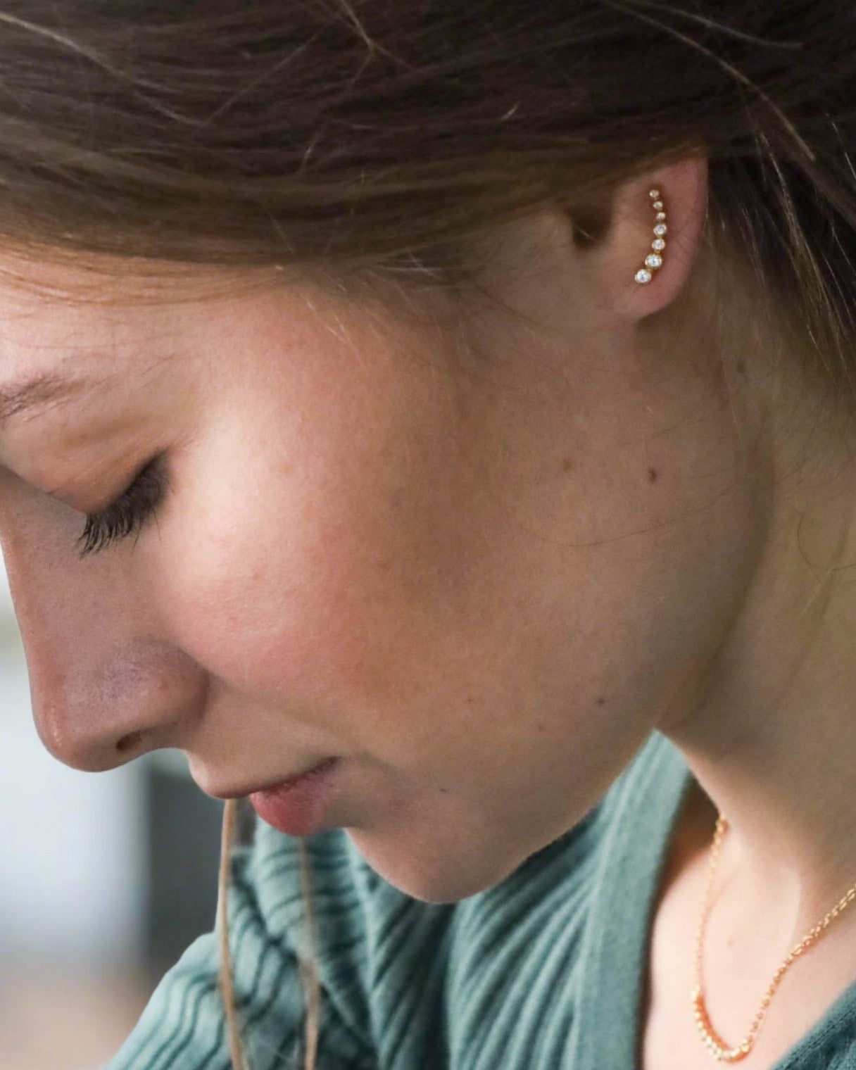 A pair of gold-plated sterling silver ear climbers with cubic zirconia stones set in a curved design.