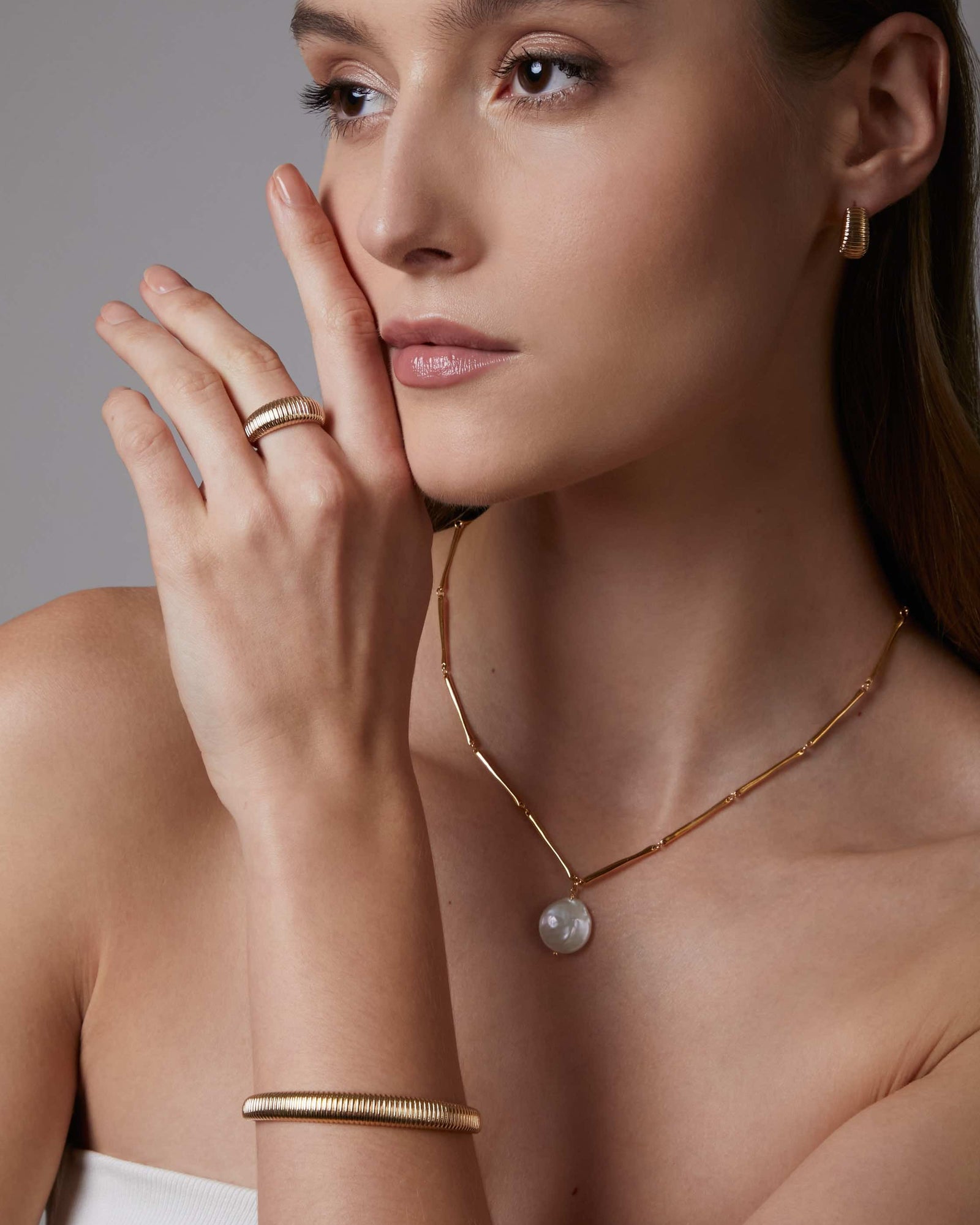 gold vermeil gold ribbed dome ring on a neutral background