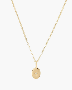Gold necklace with a small pendant on a white background