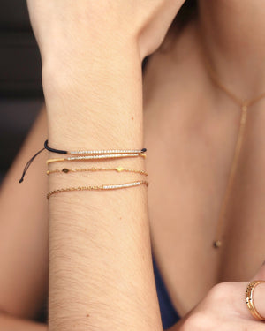 Gold bracelet with geometric accents on a woman's arm