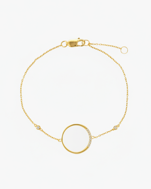 A gold-plated sterling silver bracelet with a circular charm adorned with sparkling cubic zirconia stones, featuring a chain link design and A clasp.