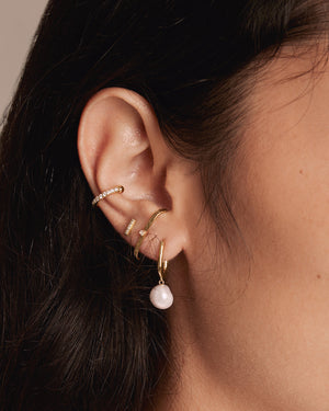 a woman wearing 4 different earrings in her right ear