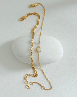 Gold bracelet with a pearl on a white stone