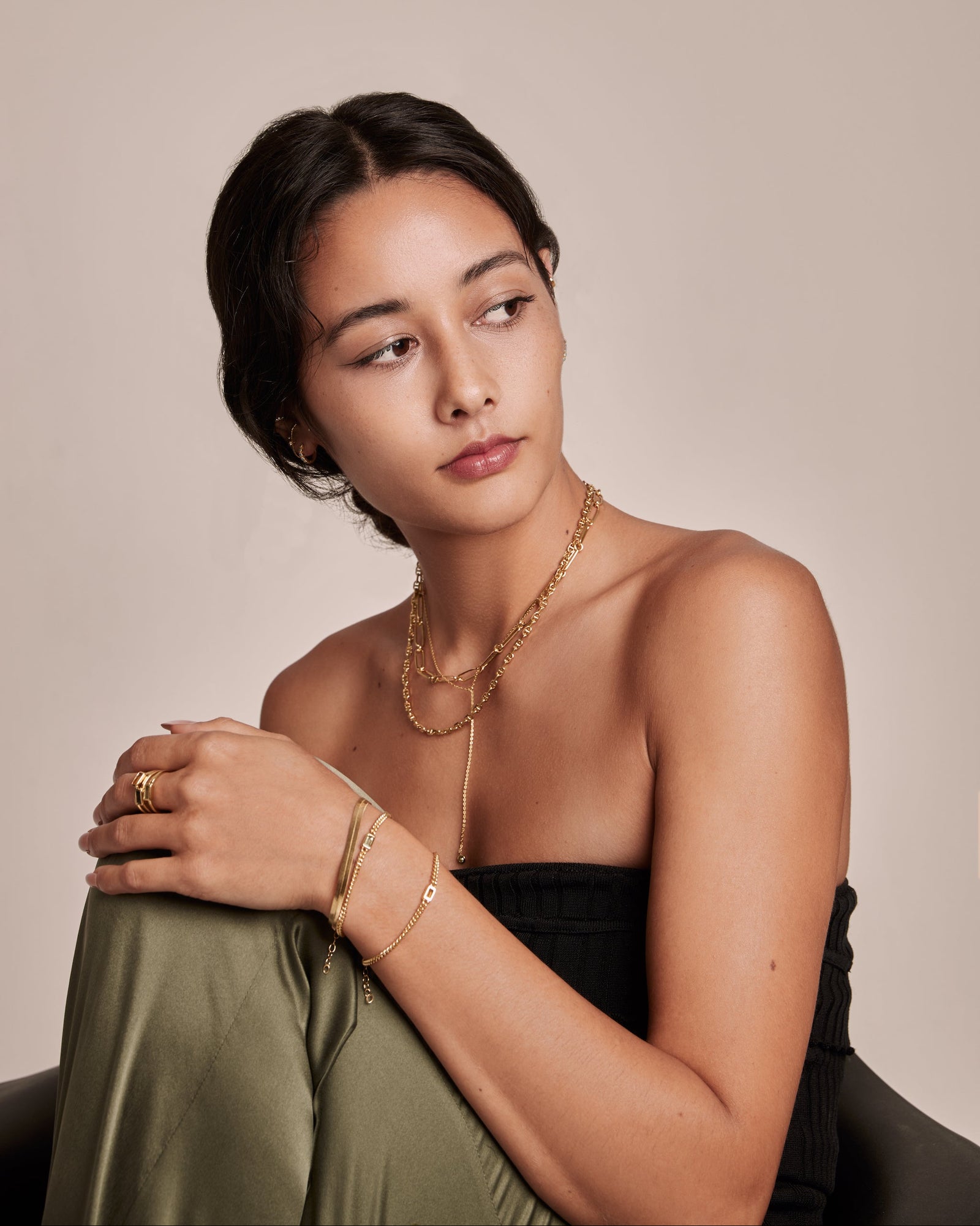 Gold bracelet with a blue rectangular gemstone on a light grey background