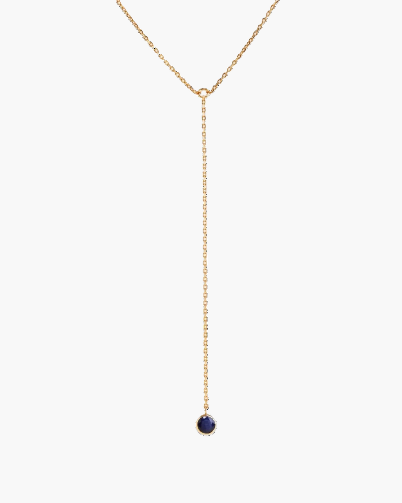 Gold necklace with a dark blue gemstone on a white background