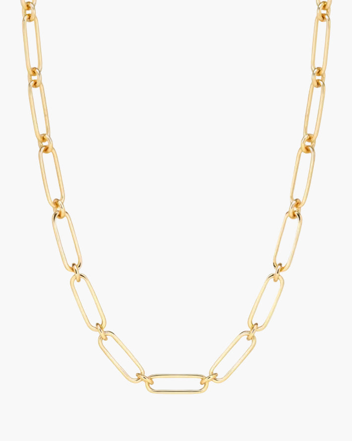 Gold chain necklace on a light beige background