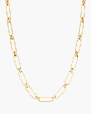 Gold chain necklace on a light beige background