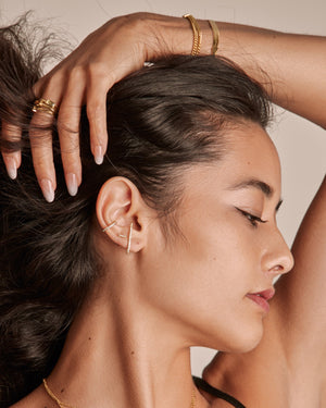 a woman wearing an ear suspender, par stud earrings and an ear cuff all with cubic zirconia stones