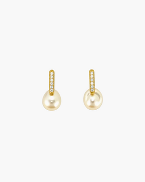 Pair of pearl earrings with gold accents on a light grey background