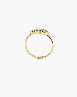 A gold ring with three small light green marquise-cut gemstones clustered at the top, photographed on a clean white background.