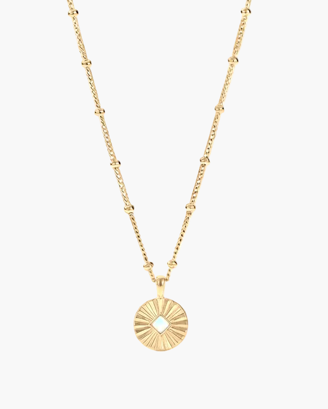 Gold necklace with a sunburst pendant on a white background