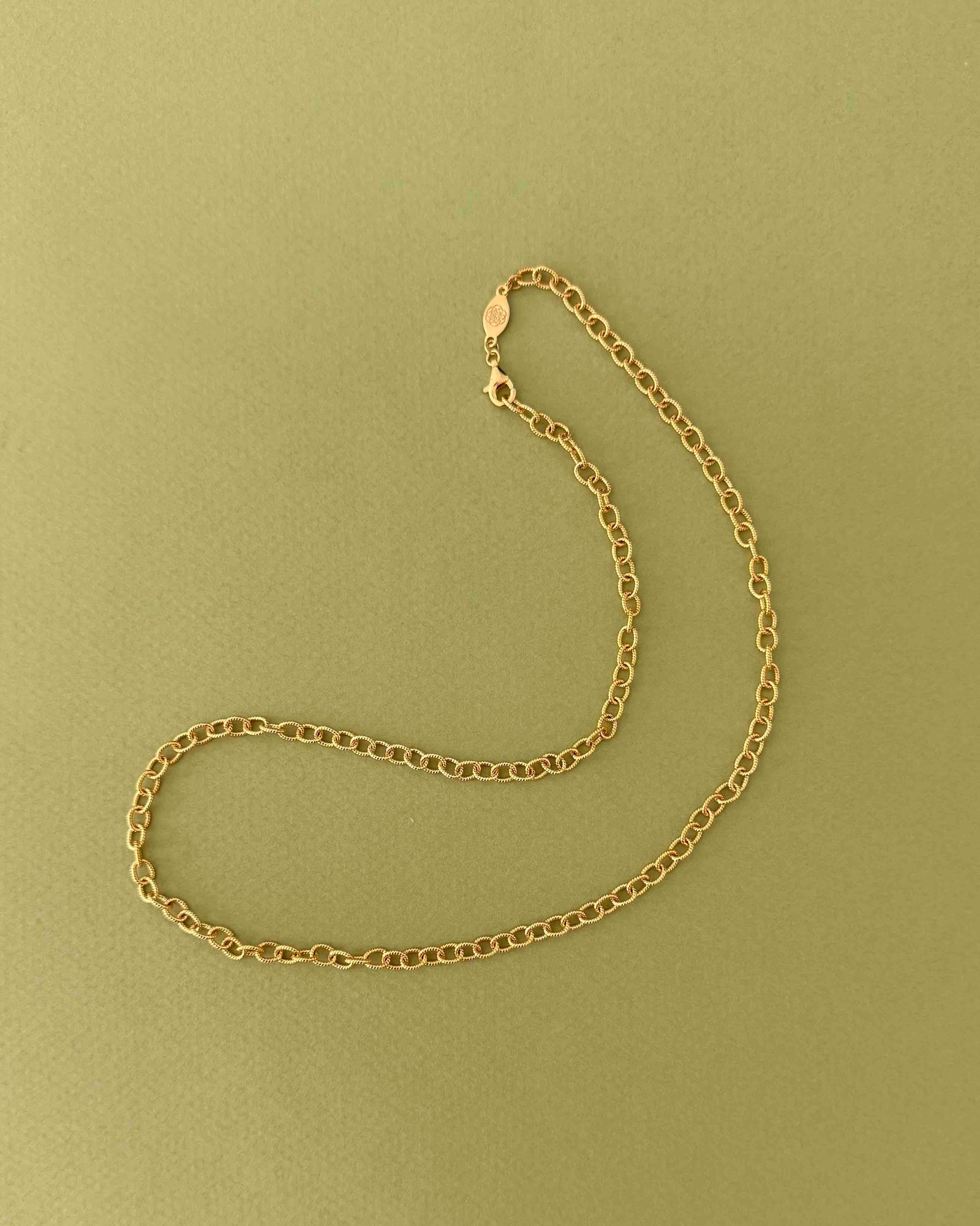 gold textured cable chain necklace on a light grey background