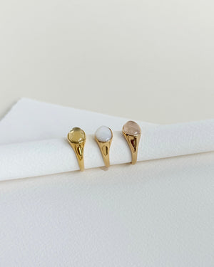 Three gold rings with different designs on a white surface
