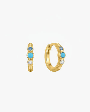 Gold hoop earrings with blue gemstones on a white background