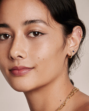 woman wearing a mix of earrings on her left ear