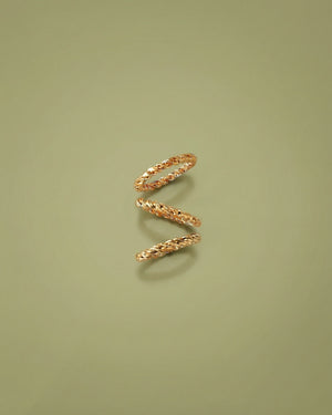 Gold spiral ring on a green background