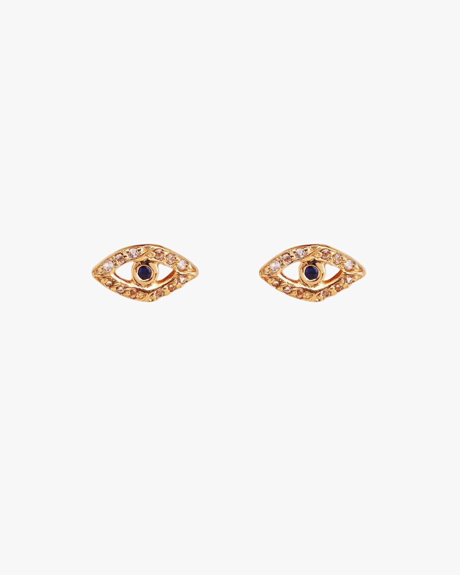 Gold eye-shaped earrings with blue sapphire on a white background
