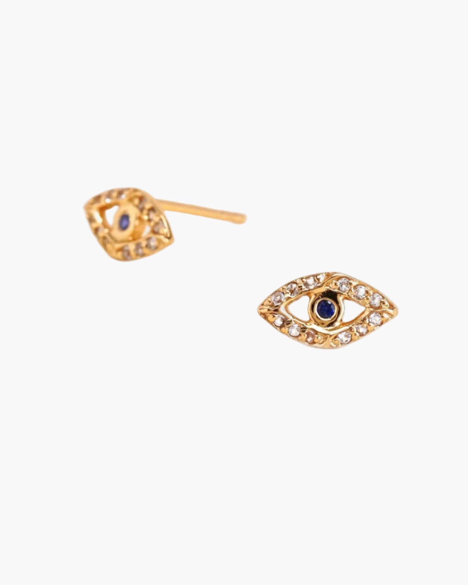Gold eye-shaped earrings with blue sapphire on a white background