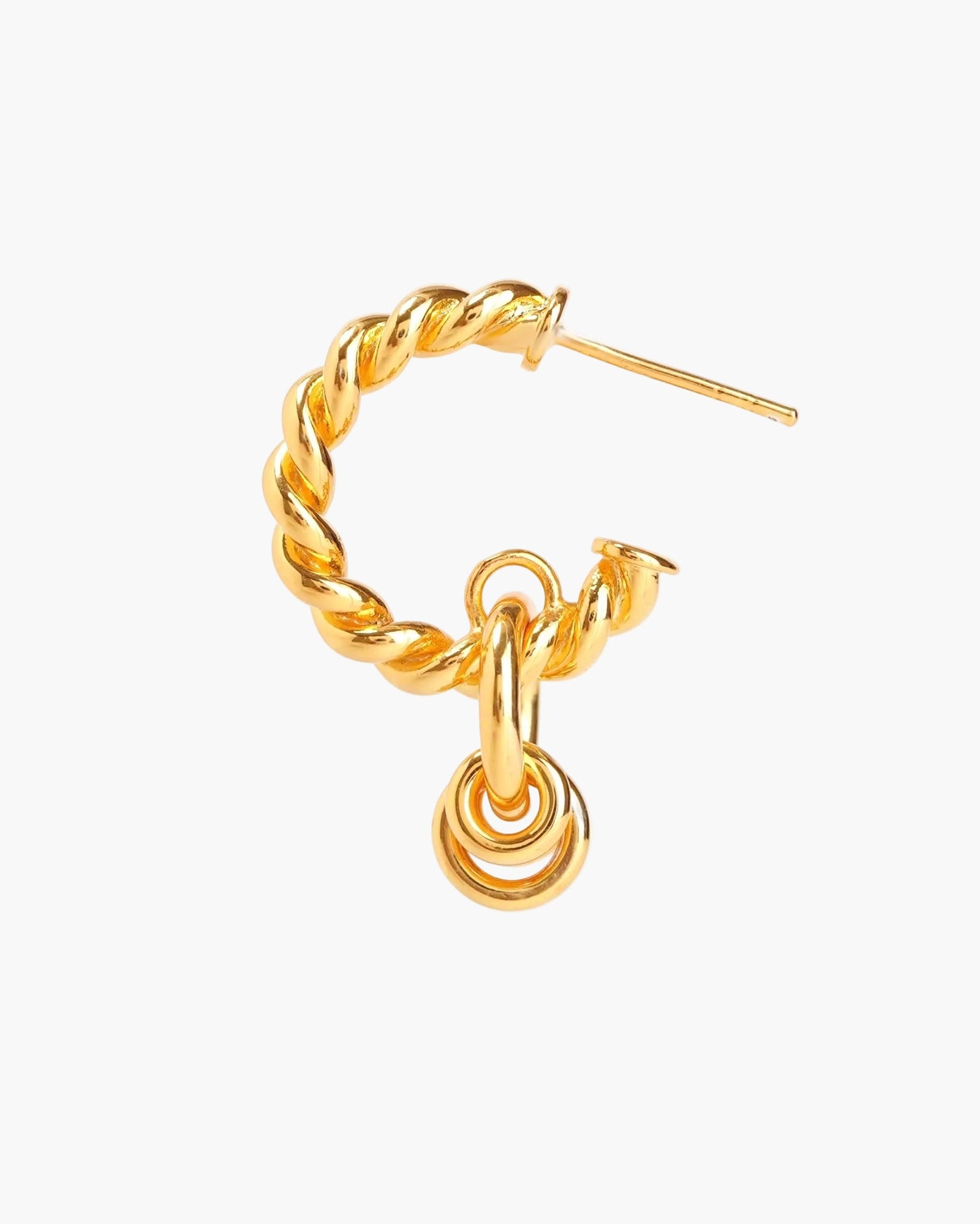 Gold twisted hoop earrings on neutral background
