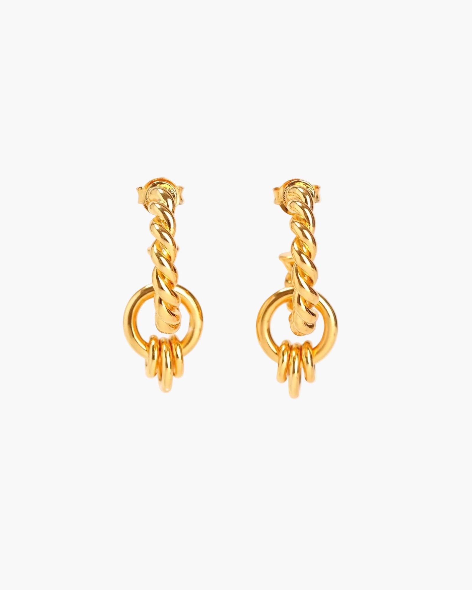Gold twisted hoop earrings on neutral background