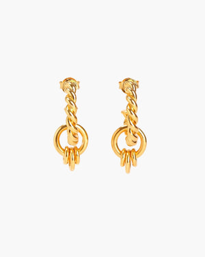 Gold twisted hoop earrings on neutral background