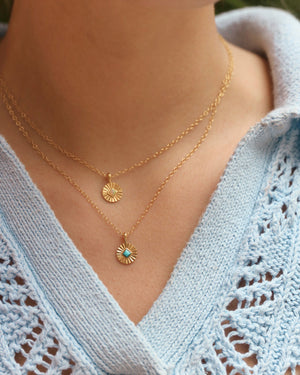 a photoshoot of a gold  Soleil charm necklace with Turquoise and with opal