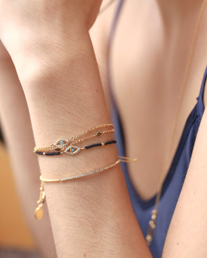 woman wearing gold dipped evil eye chain bracelet