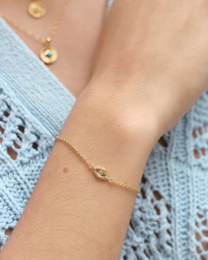 woman wearing gold dipped evil eye chain bracelet