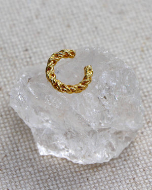 gold twisted conch cuff on a clear crystal rock