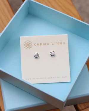 silver sparkling bubble bezel  stud earrings on a blue box